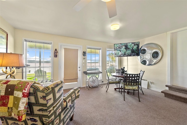 carpeted dining room with ceiling fan