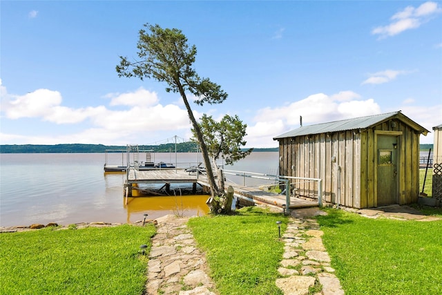 view of dock featuring a water view, boat lift, and a yard