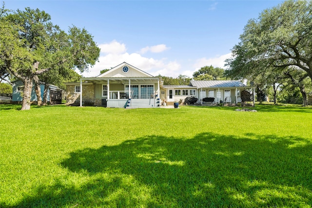 rear view of property featuring a porch and a yard