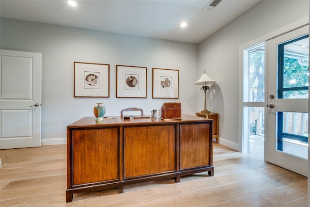 home office featuring french doors, a healthy amount of sunlight, and light wood-type flooring