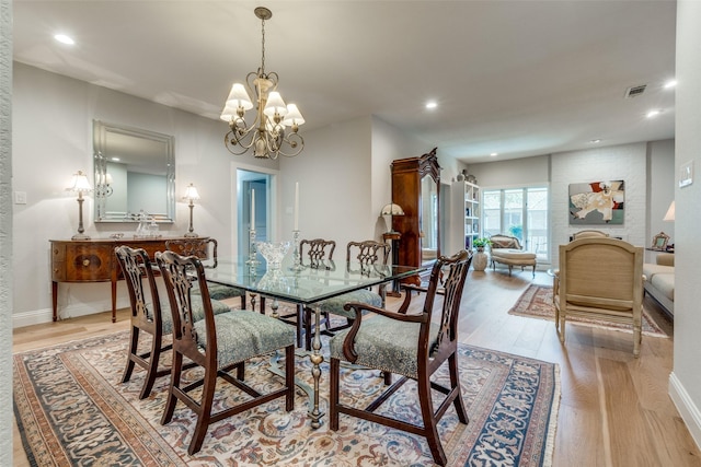 dining space featuring light hardwood / wood-style floors and a notable chandelier