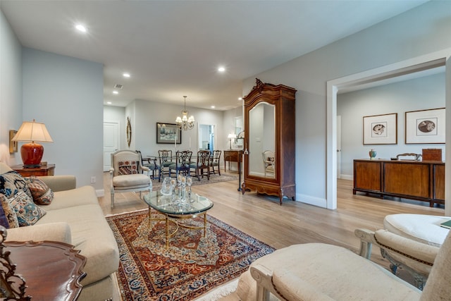 living room featuring light hardwood / wood-style flooring and a notable chandelier