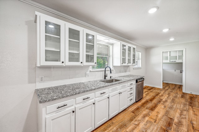 kitchen with white cabinets, backsplash, dishwasher, wood-type flooring, and sink