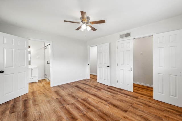 unfurnished bedroom featuring ceiling fan, connected bathroom, a closet, and light wood-type flooring