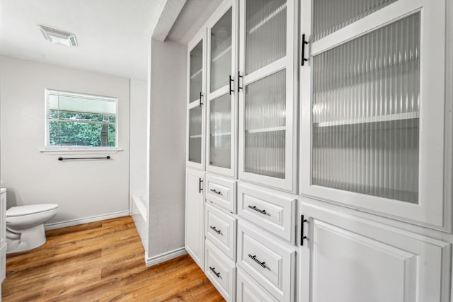 interior space with toilet and hardwood / wood-style floors