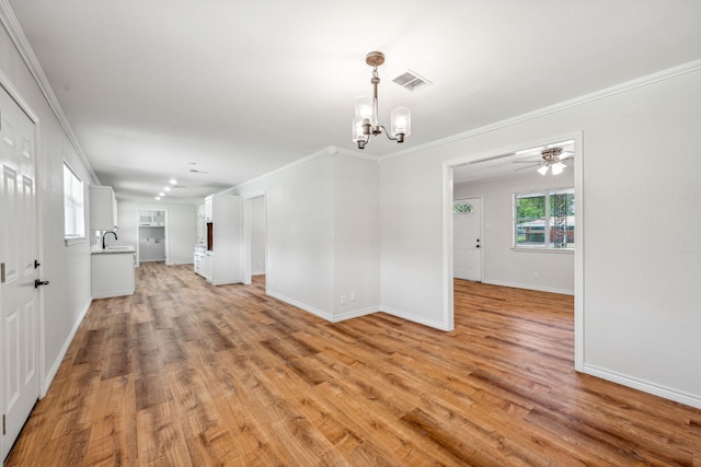 unfurnished living room with ornamental molding, sink, light hardwood / wood-style flooring, and a notable chandelier