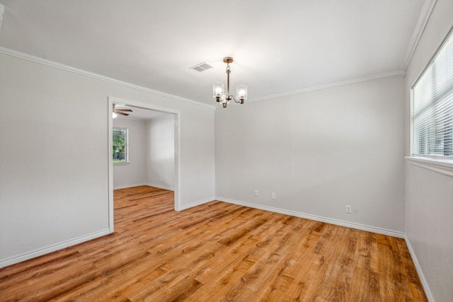 unfurnished room featuring ornamental molding, a notable chandelier, and light hardwood / wood-style floors