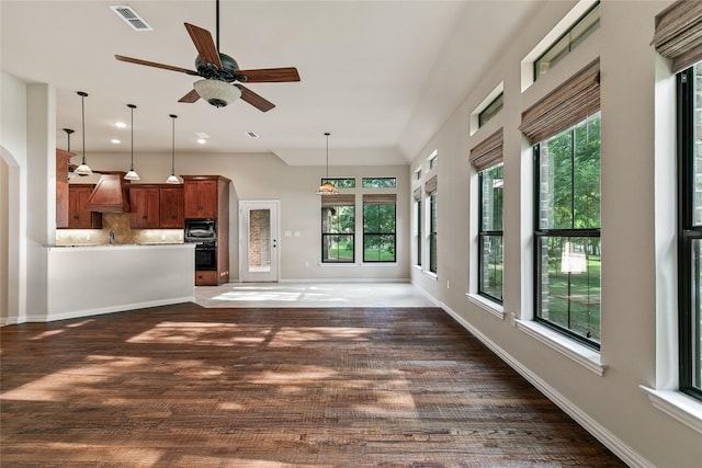 unfurnished living room with ceiling fan, plenty of natural light, and dark hardwood / wood-style floors