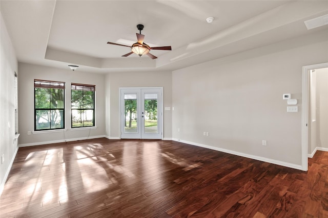 spare room featuring french doors, a raised ceiling, ceiling fan, and dark hardwood / wood-style floors