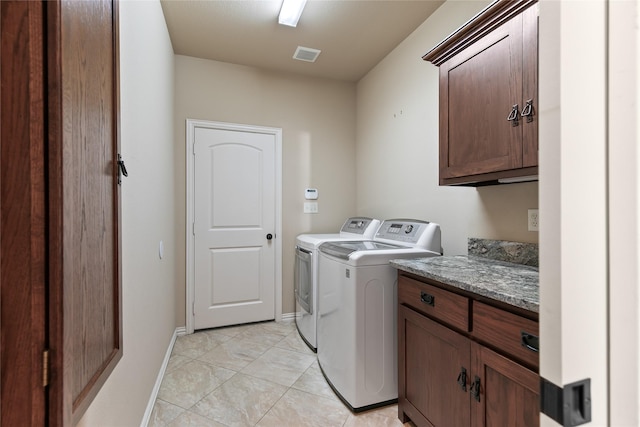 washroom with cabinets, light tile patterned floors, and washer and clothes dryer