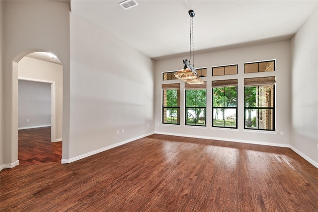 unfurnished room featuring dark hardwood / wood-style flooring and a chandelier