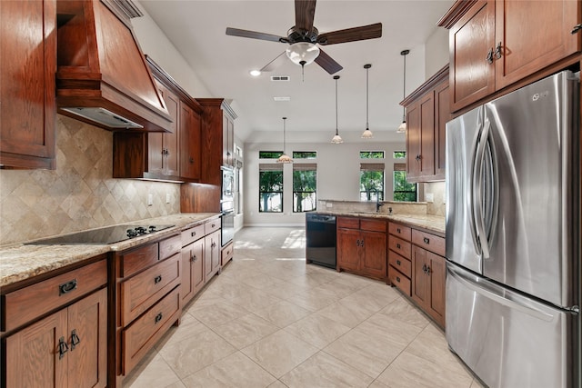 kitchen featuring light stone countertops, custom exhaust hood, pendant lighting, black appliances, and backsplash