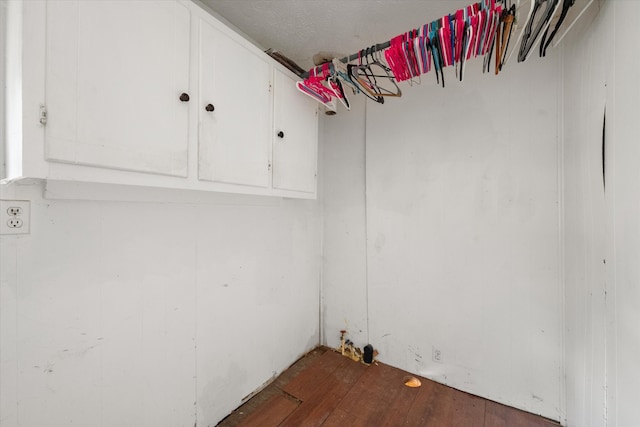 laundry area featuring cabinets and hardwood / wood-style flooring