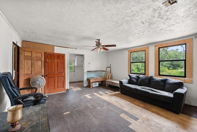 living room featuring ceiling fan, a textured ceiling, and hardwood / wood-style flooring