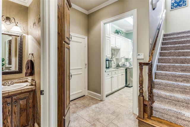 interior space with ornamental molding, vanity, washer / clothes dryer, and tile patterned flooring