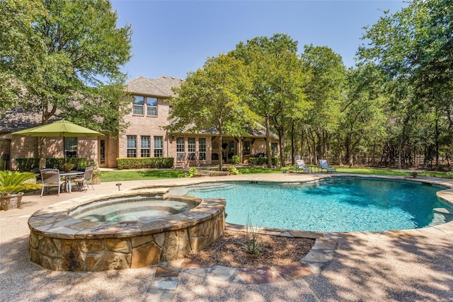 view of swimming pool featuring a pool with connected hot tub and a patio area