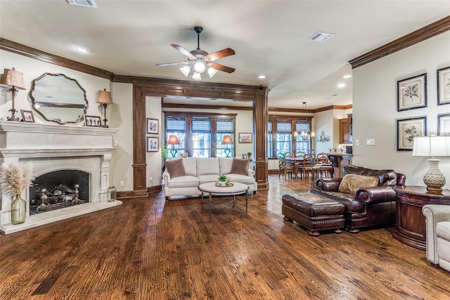 living room featuring ceiling fan, hardwood / wood-style flooring, crown molding, and a premium fireplace