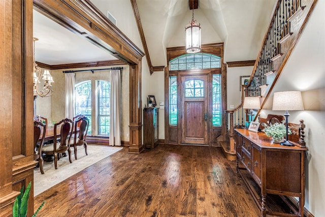 foyer entrance with high vaulted ceiling, dark hardwood / wood-style floors, and ornamental molding