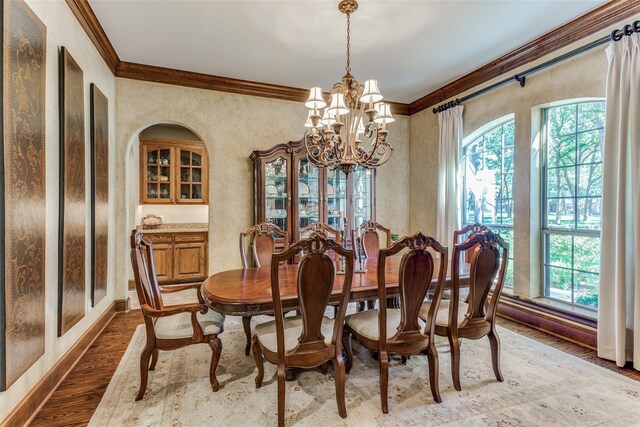 dining area featuring hardwood / wood-style flooring, a chandelier, and crown molding