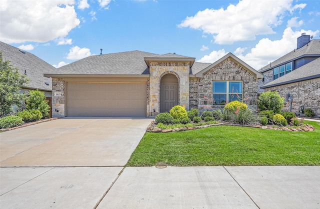 view of front of property with a garage and a front lawn