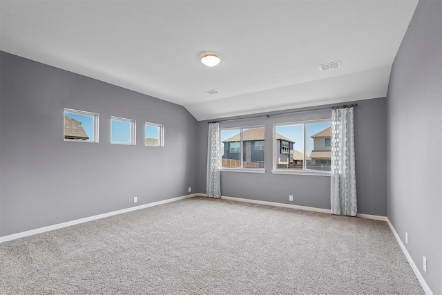 carpeted empty room with lofted ceiling