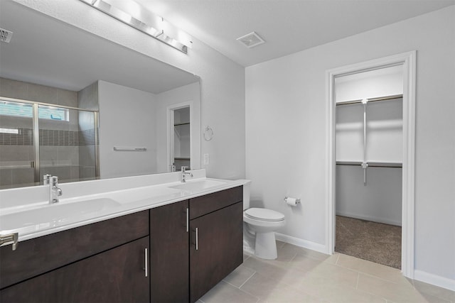 bathroom with toilet, a shower with door, vanity, and tile patterned flooring