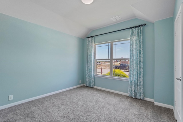 spare room featuring lofted ceiling and carpet floors