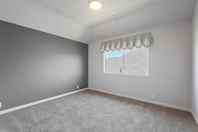 carpeted spare room featuring vaulted ceiling