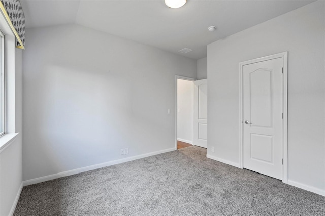 unfurnished bedroom featuring carpet floors and lofted ceiling