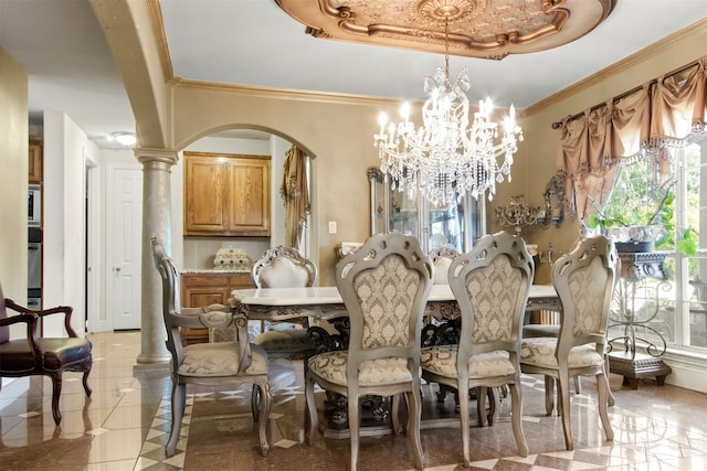 dining space with a tray ceiling, decorative columns, a notable chandelier, and ornamental molding