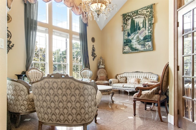 living area with high vaulted ceiling and a notable chandelier