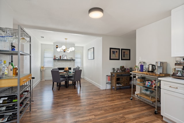 dining area with dark wood-type flooring and a chandelier