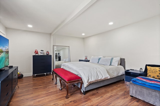 bedroom with beam ceiling and dark hardwood / wood-style floors