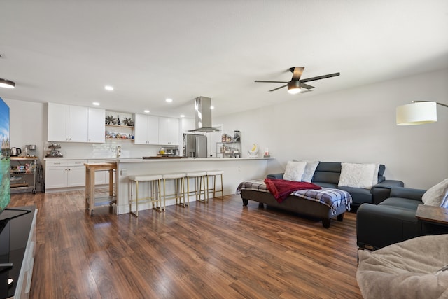 living room featuring ceiling fan and dark wood-type flooring