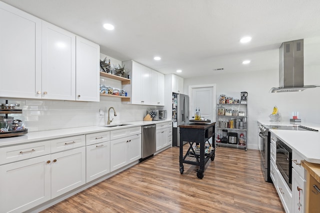 kitchen featuring stainless steel appliances, white cabinetry, sink, and ventilation hood