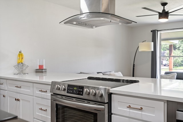 kitchen featuring white cabinets, island range hood, electric range, and ceiling fan