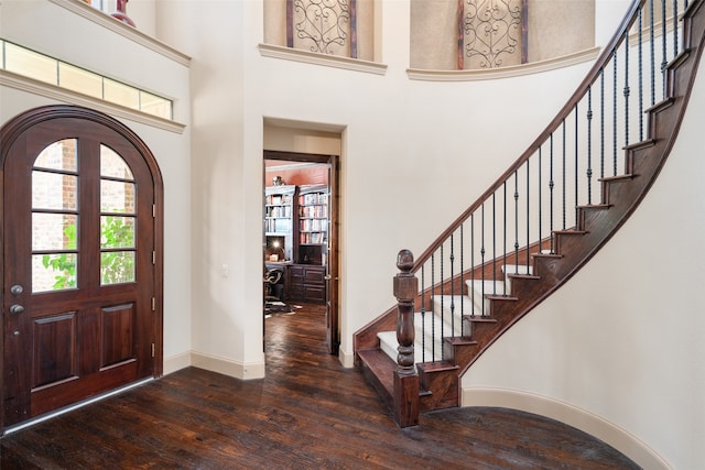 foyer entrance featuring dark wood-type flooring and a high ceiling