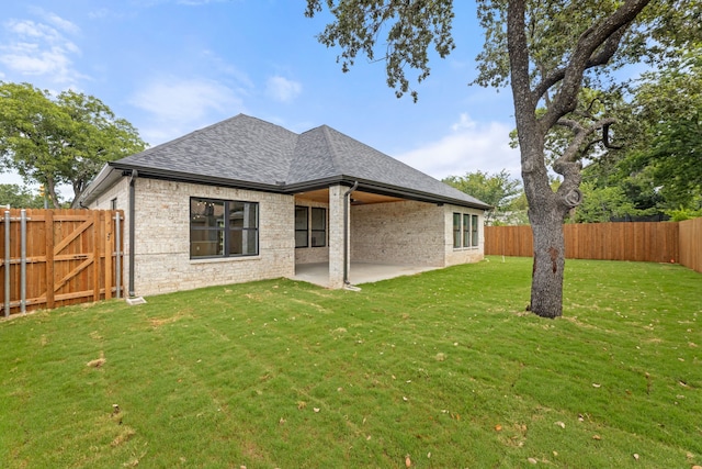 back of house with a yard and a patio