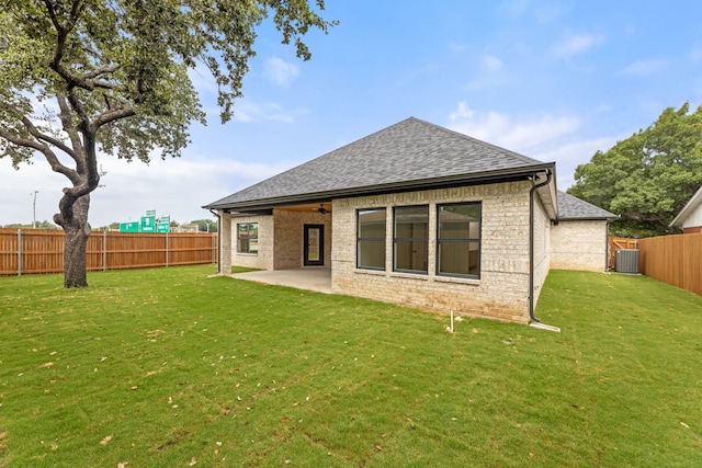 back of house with central air condition unit, a yard, and a patio