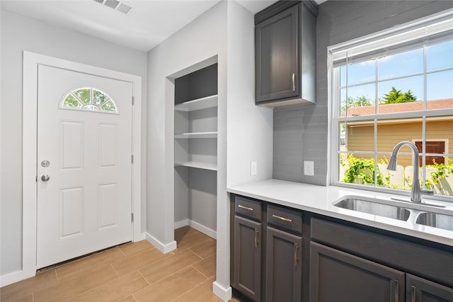 foyer entrance with sink and light tile flooring