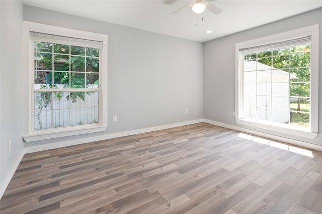 empty room with ceiling fan and light hardwood / wood-style floors