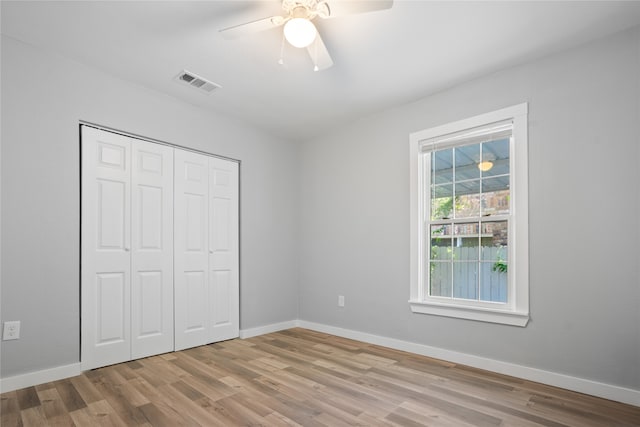 unfurnished bedroom with hardwood / wood-style floors, a closet, and ceiling fan