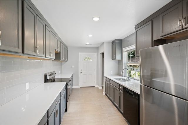 kitchen with appliances with stainless steel finishes, sink, and tasteful backsplash