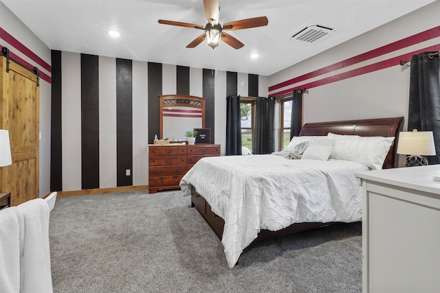 bedroom with a barn door, ceiling fan, and carpet floors