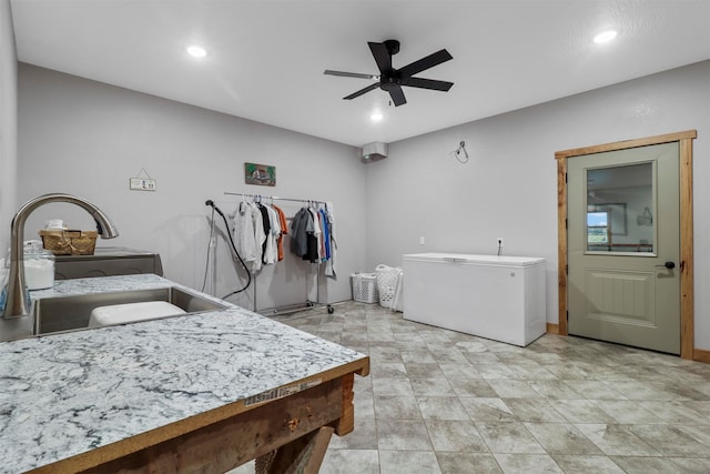 interior space featuring refrigerator, sink, and ceiling fan