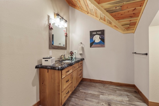 bathroom featuring hardwood / wood-style floors, vanity, and wood ceiling