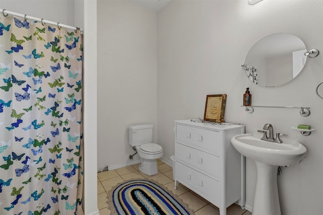 bathroom featuring tile flooring and toilet