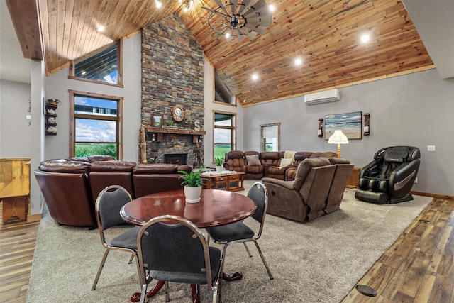 dining space with a stone fireplace, ceiling fan, wood ceiling, high vaulted ceiling, and hardwood / wood-style flooring