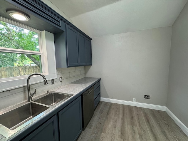 kitchen with backsplash, dishwasher, sink, and hardwood / wood-style floors