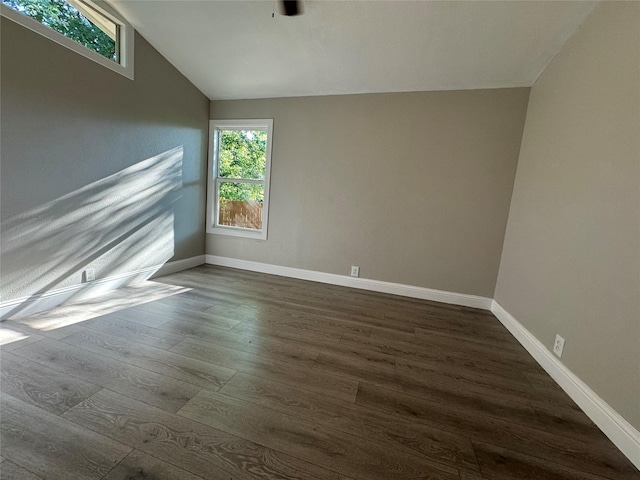 unfurnished room featuring dark hardwood / wood-style floors and vaulted ceiling